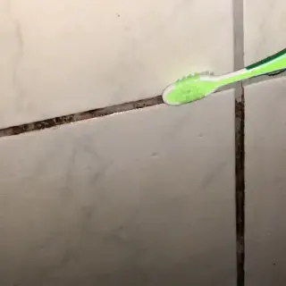 Wie man die Fugen im weißen Badezimmerfliesen sauber macht
